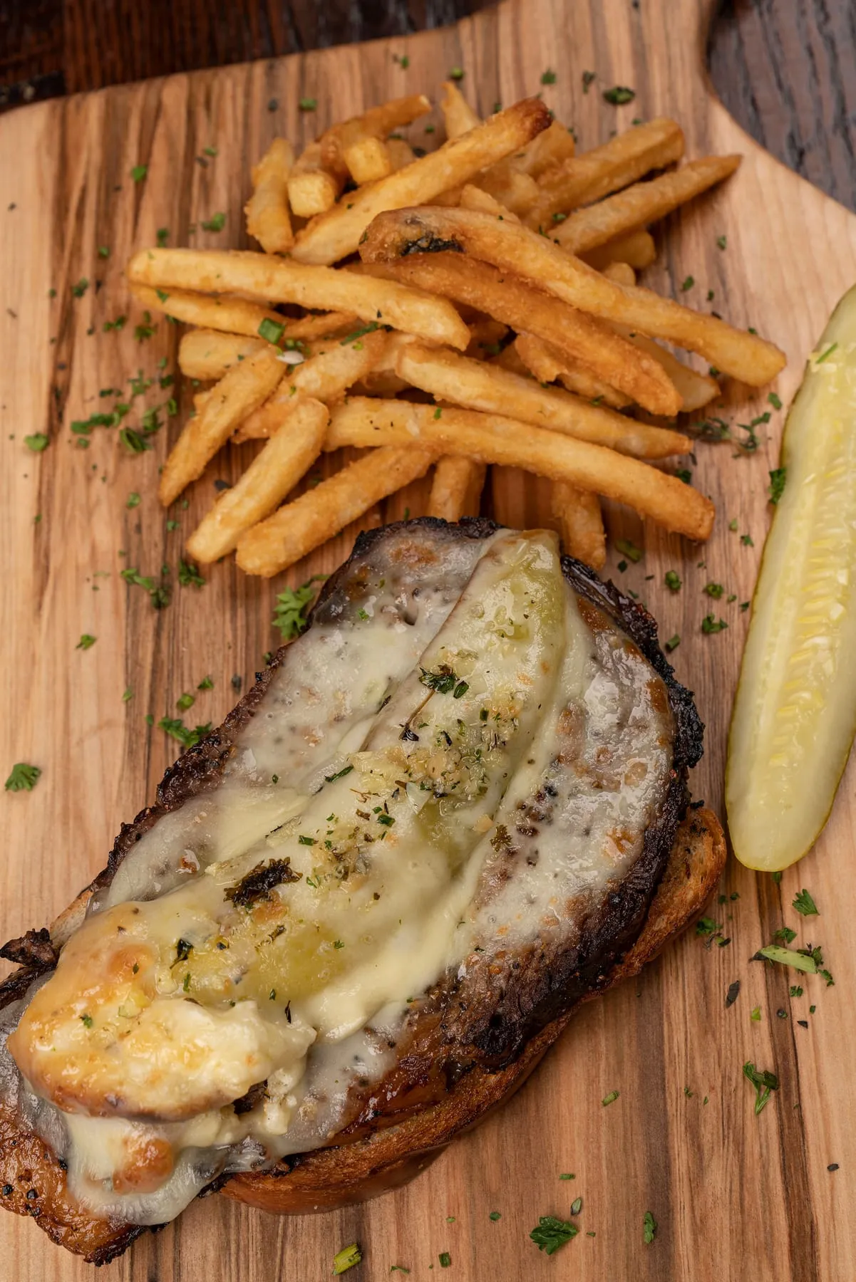 Open prime rib sandwich with fries and a pickle